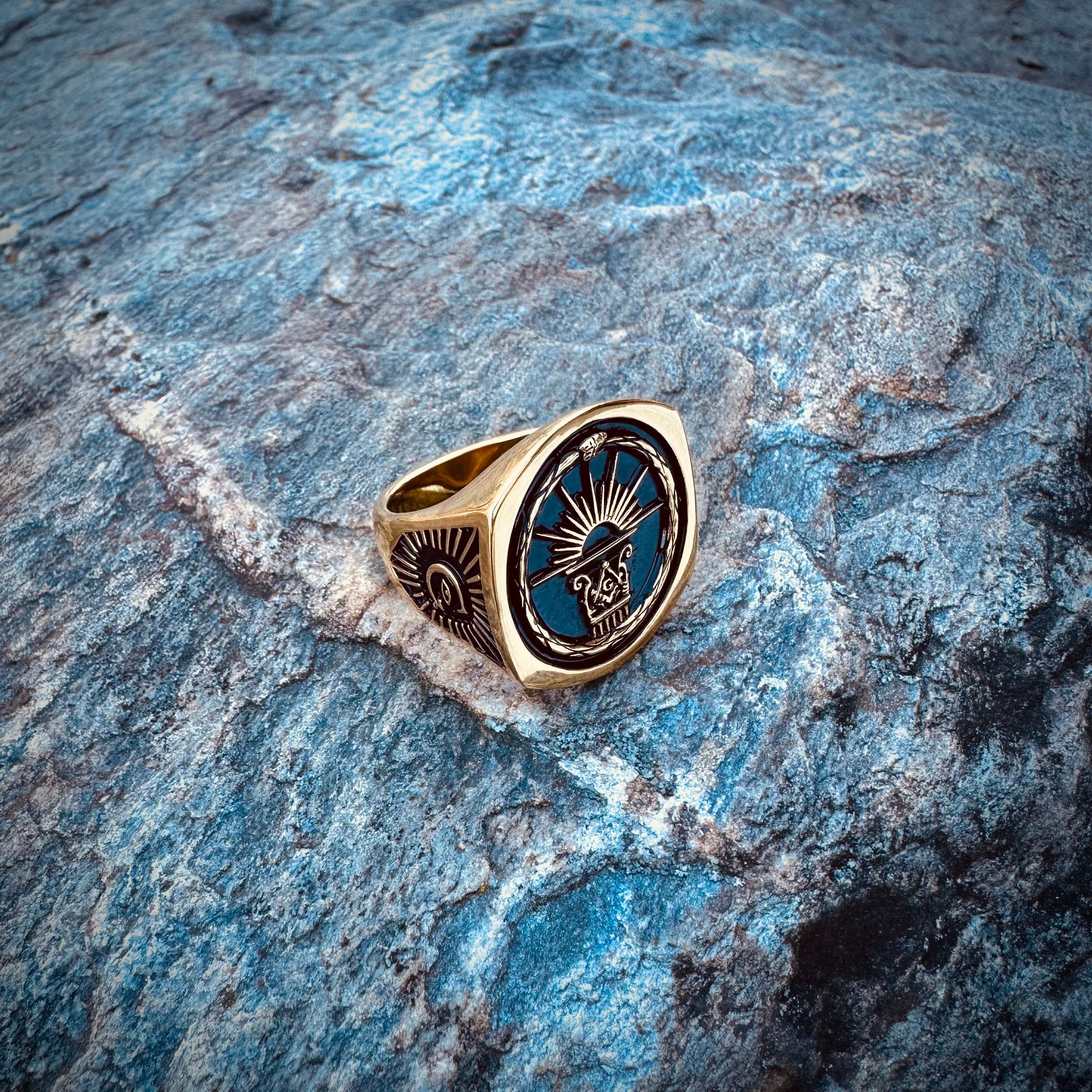 The Aurora No. 7 Masonic Ring resting on blue stone